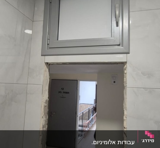 חלון אלומיניום קטן מעל דלת